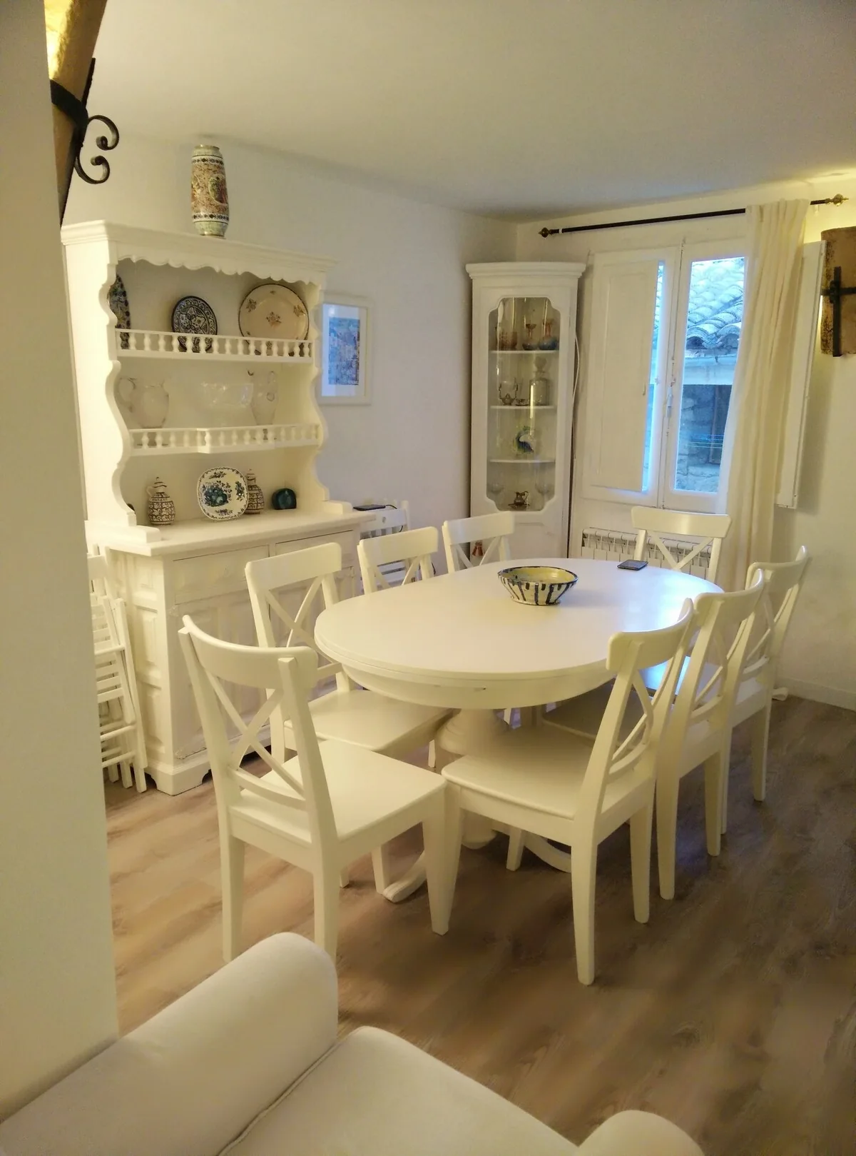 Comedor con mesa y sillas blancas junto a la zona de estar